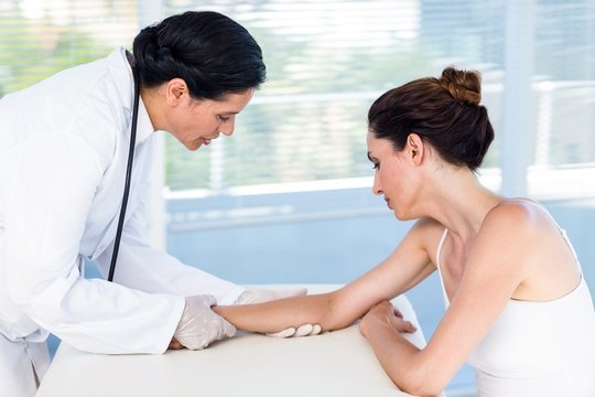 Doctor looking at her patients arm