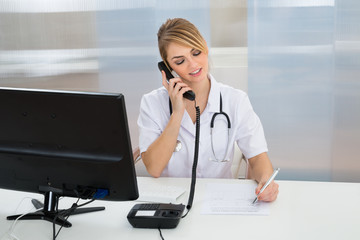 Young Female Doctor Talking On Telephone