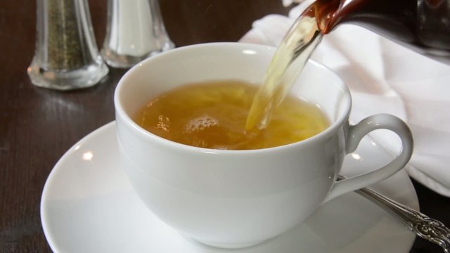 Closeup of green tea being poured into a cup
