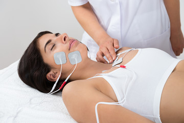 Woman Lying With Electrodes On Chest And Face