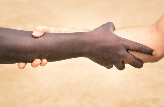 Black and white hands in modern handshake against racism