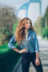 Beautiful young Caucasian girl with curly hair outdoors