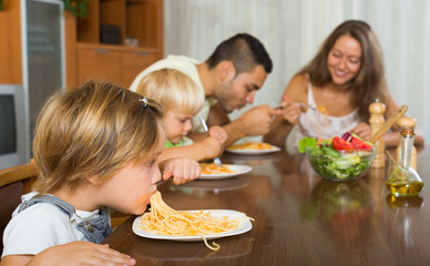 Obraz na płótnie Canvas family of four having lunch with pasta
