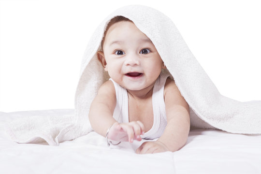 Adorable baby crawling on bed