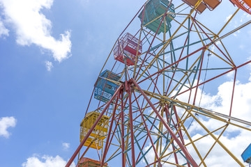 Ferris wheel and natural sunlight with blue skies.