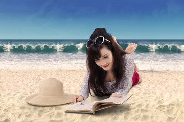 Pretty woman reading book on the beach