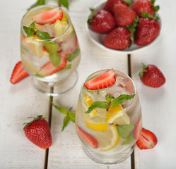 Cold drink with strawberries, lemon and mint