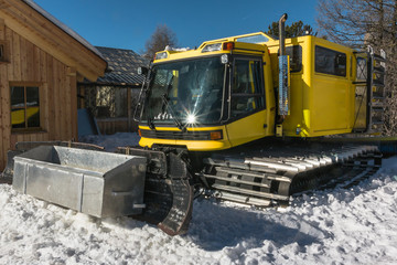 yellow tracked vehicle on snow, grooming machine