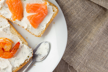 Toasts with cream cheese, shrimp and salmon copy space