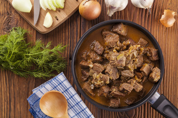 Beef stew - wooden background