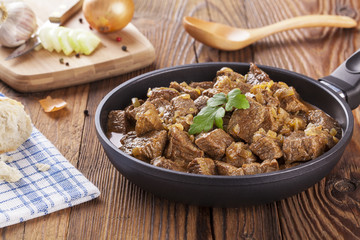 Beef stew - wooden background