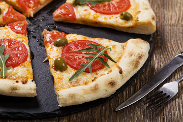 Pizza vegetarian on plate on stone black try with fresh tomatoes