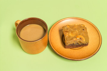 brownie cake with Cashew nuts on surface with a cup of coffee