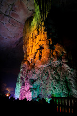 Colorfully lit stone formations in cave at guilin