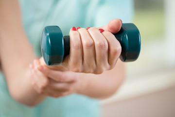 Female hand holding dumbbell
