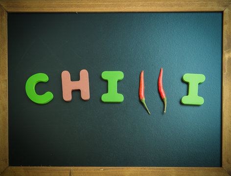 Chilli wooden word on black board