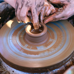 Hands working on pottery wheel