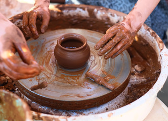 Hands working on pottery wheel