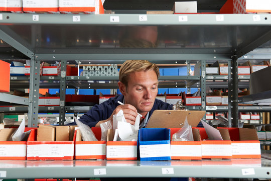 Factory Worker In Store Room Checking Stock