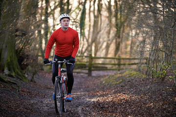 Man Riding Mountain Bike Through Woodlands