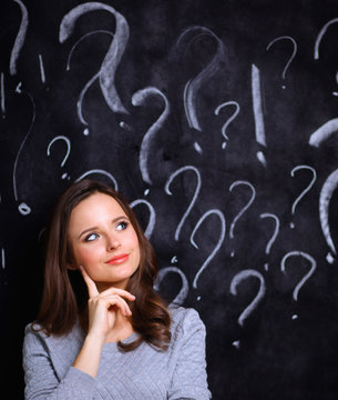 Young girl with question mark on a gray background