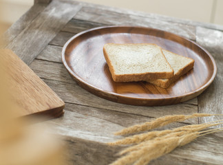 Toast bread on wooden plate and wooden breadboard