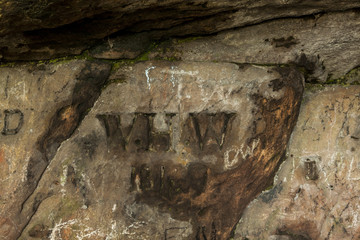 Carved graffiti. St Cuthbert's Cave. Northumberland. England.