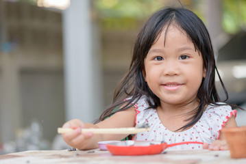 Smiling little girl plays cook on the table