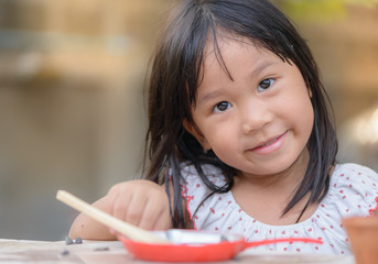 Smiling little girl plays cook on the table