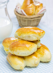 Russian pastries (pirogi) and milk on wooden table