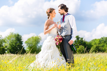 Hochzeitspaar feiert draußen Hochzeitstag mit Sekt