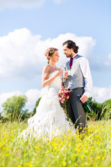 Hochzeitspaar feiert draußen Hochzeitstag mit Sekt