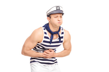 Young male sailor feeling stomach ache isolated on white
