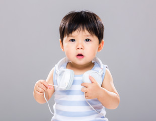 Baby boy with headphone on shoulder