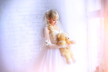 Portrait of the beautiful bride against a window indoors