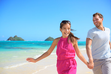 Happy couple on beach running having fun on Hawaii