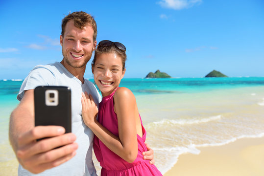 Smartphone - beach vacation couple taking selfie
