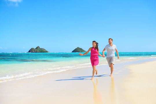 Beach happy couple on running having fun on Hawaii