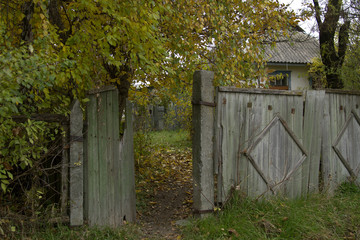 Naklejka premium rural fence, Abandoned house in autumn