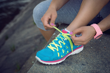 Sports woman tying her shoelaces before the jogging session.