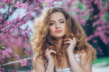 Naklejka premium Beautiful young woman with gorgeous curly fair outdoors