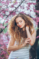 Beautiful young woman with gorgeous curly fair outdoors