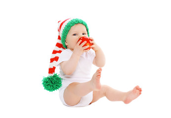 Baby in knitted hat with red apple