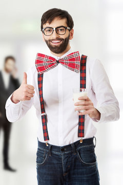 Man wearing suspenders with glass of milk.