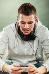 man on couch with headphones smartphone