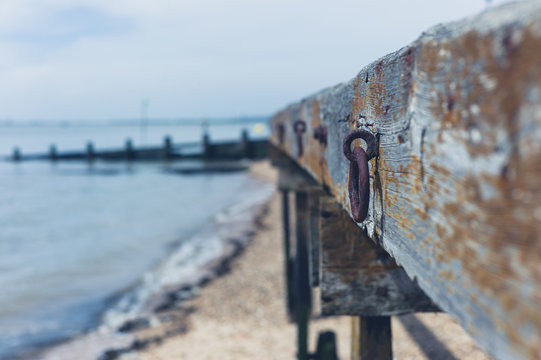 Wooden structure with rusty chain on beach