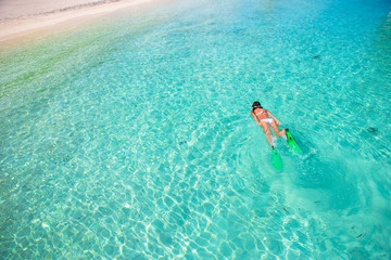 Young girl snorkeling in tropical water on vacation - obrazy, fototapety, plakaty