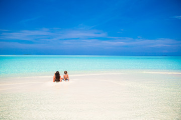 Little girl and young mother during beach vacation