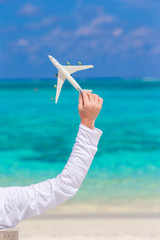 Young man with miniature of an airplane at tropical beach