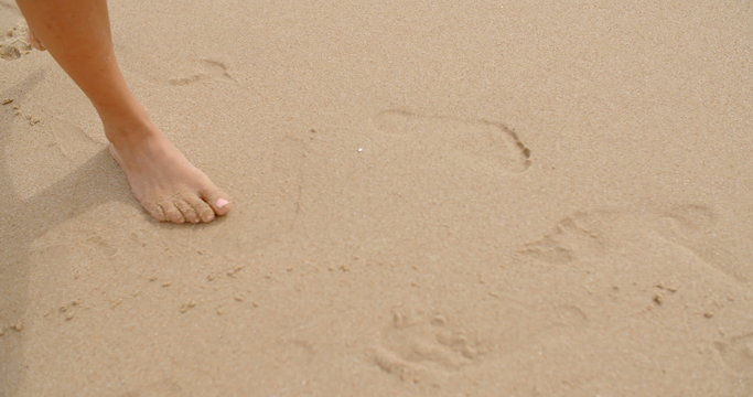 Bare Feet Coated in Sand Walking on Beach
